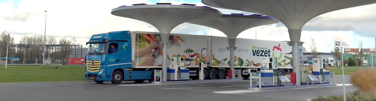 Zijaanzicht van een Dailycool vrachtwagen die geparkeerd staat bij een tankstation